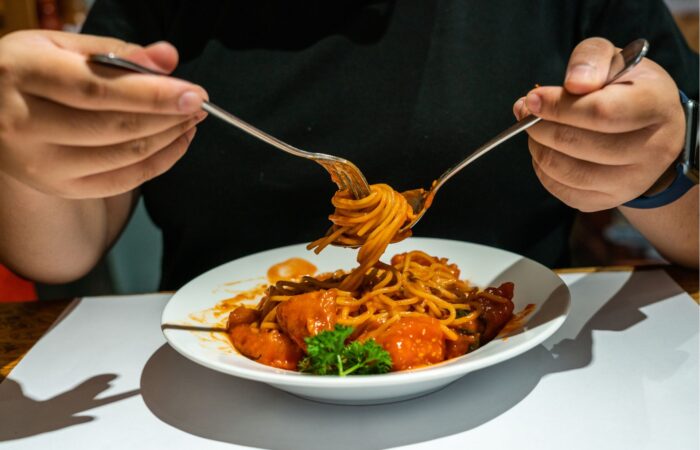 comer macarrão com colher e garfo